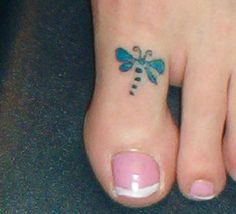 the foot has a dragonfly tattoo on it