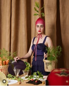 a woman in a purple dress holding two baskets filled with vegetables