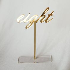 a gold cake topper with the word egitt on it's stand