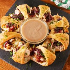 a platter filled with cranberry crescent pastries and dipping sauce