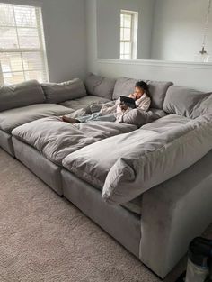 a person laying on top of a couch in a living room