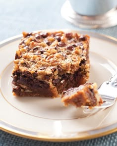 a piece of dessert sitting on top of a white plate next to a silver fork