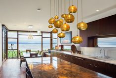 a large kitchen with marble counter tops and wooden cabinets next to a dining room table