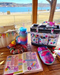 a table with some books and other items on it next to a water view window