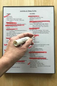 a hand is writing on a piece of paper with red marker and thumbnails