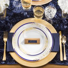 a place setting with gold and blue plates