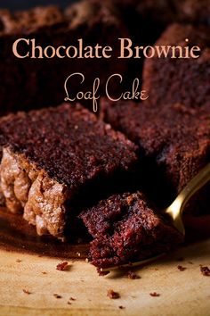 chocolate brownie loaf cake sitting on top of a wooden cutting board with a spoon in it