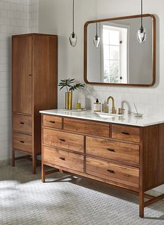 a bathroom with two sinks and a large mirror over it's counter top, in front of a white tiled wall