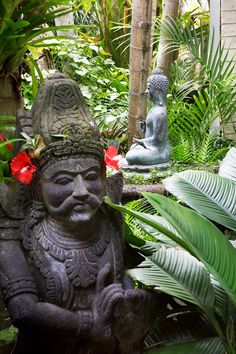 a statue sitting in the middle of some plants