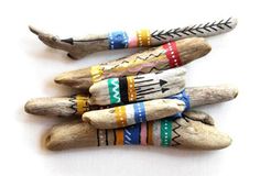 four wooden sticks with different colored designs on them and one has an arrow in the middle