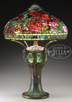 a lamp that is sitting on top of a glass tablecloth with flowers painted on it