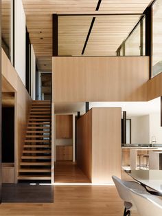 the interior of a modern house with wooden floors and stairs leading up to an upper level