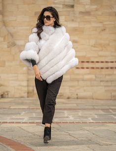 Amazing fluffy fox fur poncho in a great natural white color. A modern but also diachronic design, that can be worn in every occasion, giving style and elegance to your outfit. An ideal piece, for those who want to spoil themselves! Fluffy fox fur poncho Diagonal zipper closure Without pockets Without sleeves style In natural white color Stunning color The fur is dense ,glossy ,plush and luxuriously soft High quality lining Length 70cm The size of the poncho on the photo is One Size Finest quali Fur Poncho, Poncho Coat, Fur Cape, Luxury Gifts For Her, Real Fur Coat, Ladies Poncho, Elegant Hats, Mink Fur Coat, Cold Weather Fashion