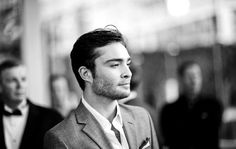 a black and white photo of a man in a suit looking off into the distance