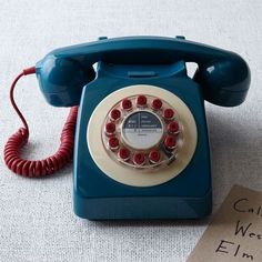 an old - fashioned rotary telephone sits on the floor next to a sign that says call me