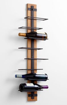 a wall mounted wine rack with three bottles on it's sides and two corks in the middle