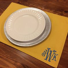 two white plates sitting on top of a yellow placemat with the word wiki written in blue