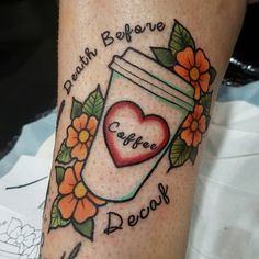 a tattoo on the leg of a woman with a jar of coffee and flowers around it