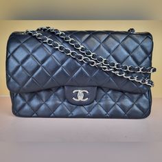 Preowned Chanel Classic Black/Burgundy Double Flap Lambskin Quilted Chain Strap Shoulder Bag. This Bag Can Be Also Worn Crossbody. Size: Large/Jumbo. Measurements: 12"W/8"H/3.5"D Condition: Please Note This Bag Has Moderate Signs Of Wear Which Includes Scuffing, Indentations, Creasing, And Discoloration. We Are A Reseller. We Do Not Possess Any Information Of The History Of The Bag. We Do Not Know If The Bag Was Repaired Or Repainted. It Does Not Seem So To The Naked Eye. Exterior: There Are Scuffs Throughout The Bag. Can Be Seen On The Exterior Flap. There Are Several Scuffs On The Base Of The Bag. There Are Also Scratches On The Exterior That Can Be Seen Throughout. There Are Pe Flap Shoulder Bag, Shoulder Bag Black, Chain Strap, Chanel Bag, The History, Chanel Classic, Classic Black, Chanel, Bag Lady