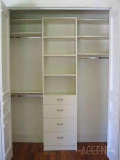 an empty closet with white shelves and drawers