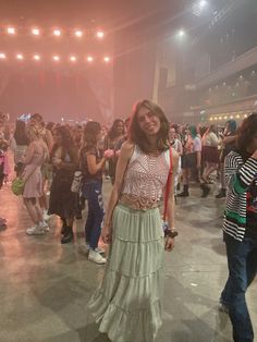 a woman standing in front of a group of people on a dance floor at a concert