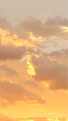 an airplane is flying in the sky at sunset or dawn with some clouds above it