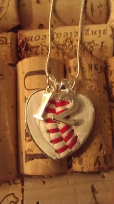 a close up of a heart shaped pendant on a necklace chain with wine corks in the background