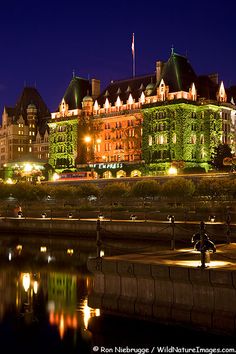 a large building lit up at night next to water