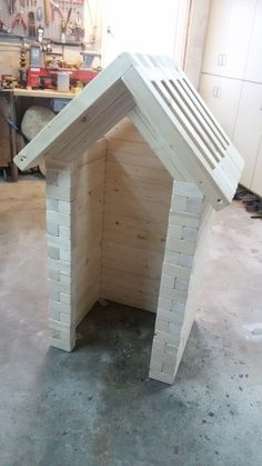 a dog house made out of wood in a garage