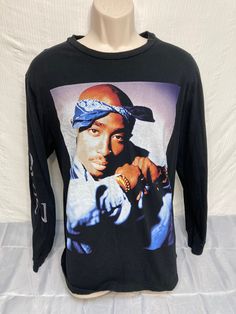 A terrific 2Pac long sleeve unisex T-shirt. Features a great full size image of 2Pac. Size XL. Approx chest size 44" Top of collar to bottom of shirt 24" sleeve length 19". Very nice condition! Long Sleeve Hip Hop T-shirt For Streetwear, Hip Hop Long Sleeve Cotton Tops, Black Long Sleeve Pre-shrunk T-shirt, Hip Hop Winter T-shirt With Screen Print, Winter Streetwear Shirt With Crew Neck, 90s Graphic Print Long Sleeve T-shirt, 90s Long Sleeve Shirt With Graphic Print, 90s Style Long Sleeve Shirt With Graphic Print, 90s Style Long Sleeve Graphic Print Shirt