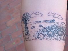 a woman's arm with a windmill and flowers tattoo on the left side of her leg