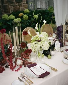 the table is set with flowers, candles and place settings for an elegant wedding reception