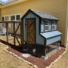 a small chicken coop in front of a house