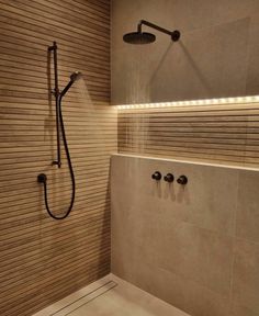 a bathroom with a shower head and hand held shower faucet in the corner