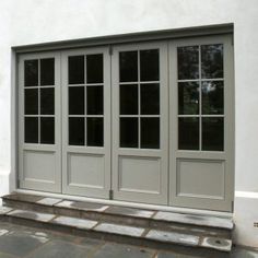 an image of a front door that is painted in gray and has three panes on each side