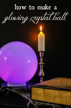 a glowing crystal ball sitting on top of a table next to a book and candle