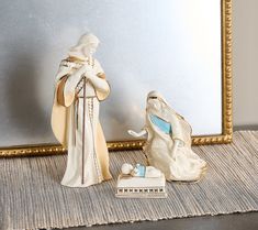 two figurines sitting next to each other in front of a mirror