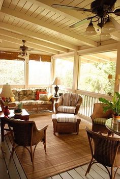 a covered porch with wicker furniture and ceiling fan