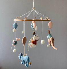 a mobile with various stuffed animals hanging from it's sides, including an elephant and giraffe