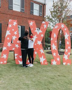 two people standing in front of the letters ao and o on display at an outdoor event