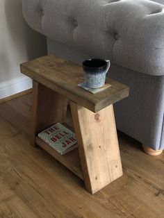 a small wooden table sitting on top of a hard wood floor next to a couch