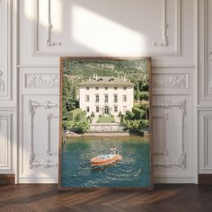 a boat floating on top of a lake in front of a white building with trees