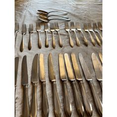 a table topped with lots of silverware on top of a cloth covered tablecloth