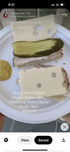 a white plate topped with two slices of cucumber next to another piece of cheese