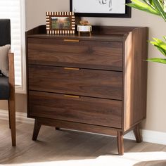 a wooden dresser sitting next to a chair in a room with a plant on top of it