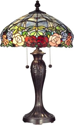 a lamp that is sitting on top of a table with a flower design on it