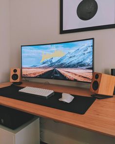 a computer monitor sitting on top of a wooden desk next to a keyboard and mouse