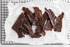 some pieces of beef sitting on top of a white paper