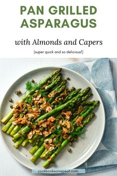 asparagus with almonds and capers on a white plate next to a blue napkin