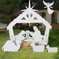 an outdoor nativity scene with white paper cutout figures and a star above the manger